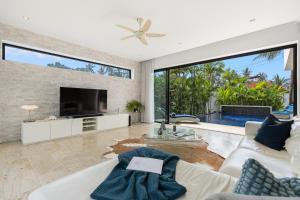 a living room with a tv and a large window at Baan Siri Varee - Private Village Luxury in Ban Tai, Koh Samui in Mae Nam