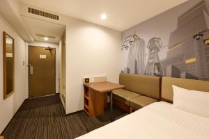 a hotel room with a bed and a desk at Via Inn Shin Osaka in Osaka