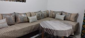 a brown couch with a table in a room at Petit appartement in Meknès +4 photos