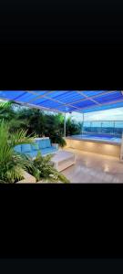 Una vista de un patio con sillas azules y una vista al océano. en Agréable appartement en rooftop, en La Cabirma
