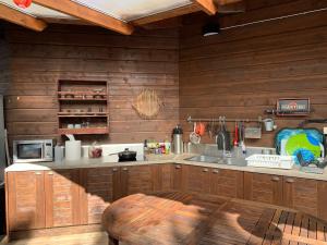 a kitchen with wooden walls and a wooden table at Luxury Seaside Hideaway, Sauna and Sunset Views in Eckerö