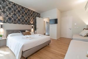 a bedroom with two beds and a wall at Hotel Grifoni in Venice
