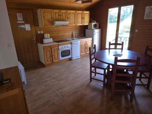 a kitchen with a table and chairs and a kitchen with white appliances at CHALET 6 Personnes in Uxelles