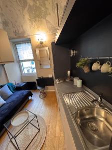 een keuken met een wastafel en een bank in een kamer bij Via Corradi in Sanremo +7 foto's