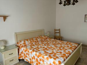 a bedroom with a bed with an orange comforter at Casa vacanze di Carla in Savona