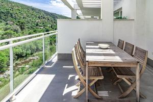 a wooden table and chairs on a balcony at Modern 3 Bedroom Retreat in Benahavís in Benahavís