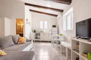 a living room with a couch and a kitchen at Apartments Martinis in Vis