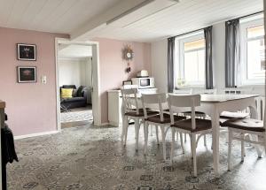 a dining room with a white table and chairs at Maison Cyriax in Harzgerode