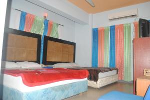 two beds in a room with colorful curtains at Hotel Sea Alif in Cox's Bazar