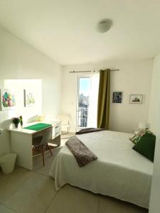 Un dormitorio con una cama y un escritorio con una mesa. en Sliema, Villa Savoia Luxury Apartment for 5 Guests, en Il-Gżira