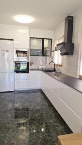 a white kitchen with a refrigerator and a sink at Apartamento con encanto in Torredembarra