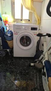 a washing machine in a kitchen with a bike next to it at Apartamento con encanto in Torredembarra