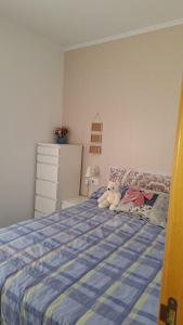 a teddy bear sitting on a bed in a bedroom at Apartamento con encanto in Torredembarra +4 photos