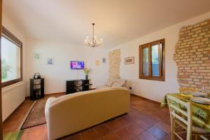 a living room with a couch and a brick wall at La Casa del Relax - Near Lignano and Grado in San Gervásio