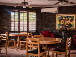 comedor con 2 mesas y sillas en Lavender Lane Guesthouse, en Kathu