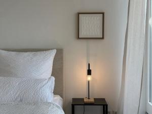 a bedroom with a bed and a lamp on a table at Flow Living Penthouse in See- und Bahnhofsnähe in Herrsching am Ammersee