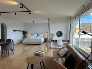 a living room with a bed and a couch at Flow Living Penthouse in See- und Bahnhofsnähe in Herrsching am Ammersee +20 photos