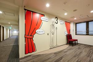 an office hallway with a wall mural of a man in a suit at Via Inn Shin Osaka in Osaka