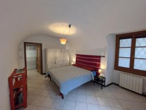 a bedroom with a bed with a red and white blanket at Casa Pievani - Bernina Express in Tirano