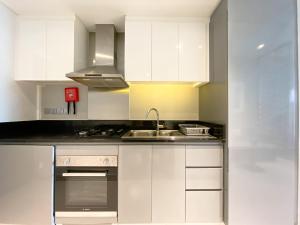 a kitchen with white cabinets and a sink at Vista Chic Studio in Prive By Damac-14 in Dubai