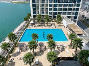 an overhead view of a swimming pool with palm trees and a building at Vista Chic Studio in Prive By Damac-14 in Dubai