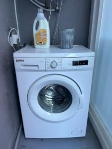 a washing machine with a bottle of detergent on top of it at CAMIÑO DA PRATA in Redondela