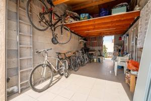 zwei Fahrräder hängen an der Wand einer Garage in der Unterkunft Villa bord de mer in Gruissan