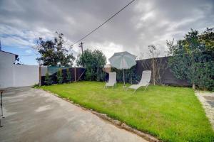 two chairs and an umbrella in a yard at Murches' House in Alcabideche