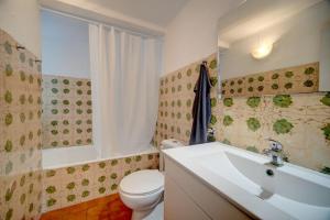 a bathroom with a white toilet and a sink at Murches' House in Alcabideche +6 photos