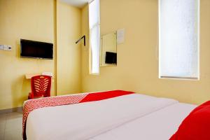 a bedroom with a large white bed and a window at Dancenter Helvetia Near Plaza Millenium Formerly Sunny Inn in Medan