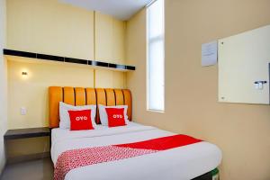 a bedroom with a bed with two red pillows at Dancenter Helvetia Near Plaza Millenium Formerly Sunny Inn in Medan