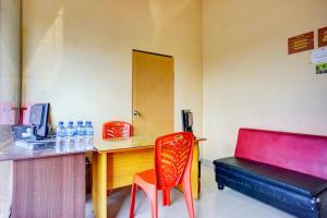 a room with a desk and a red chair at Dancenter Helvetia Near Plaza Millenium Formerly Sunny Inn in Medan