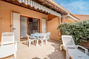 eine Terrasse mit einem Tisch und Stühlen auf einem Haus in der Unterkunft Villa bord de mer in Gruissan