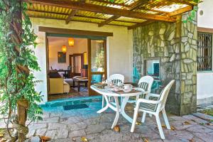 una mesa y sillas en un patio con una pared de piedra en Casa La Campanella, en Germignaga