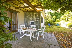Una mesa blanca y sillas en un patio. en Casa La Campanella, en Germignaga
