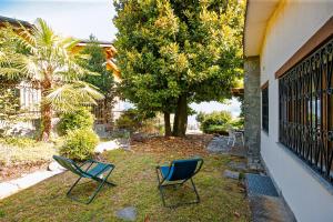 dos sillas sentadas en el césped junto a una casa en Casa La Campanella, en Germignaga 16 fotos más