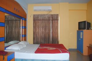 1 dormitorio con 1 cama y TV en una habitación en Hotel Sea Alif, en Cox's Bazar