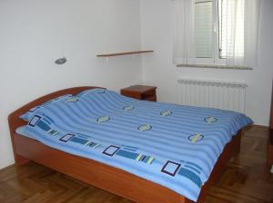 a bed with a blue blanket on top of it at kutlesa 2 in Opatija