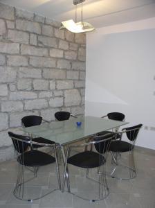 a glass table and chairs in front of a brick wall at kutlesa 2 in Opatija