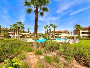 马拉喀什Prestigia Luxury Appart 2 Room的有游泳池和棕榈树的度假村