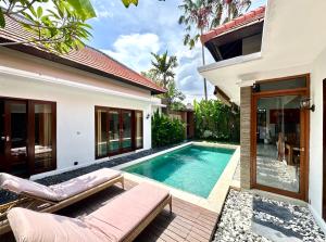 a villa with a swimming pool and a house at Villa Searenity Seminyak in Seminyak