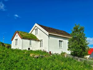 an old house with a grass roof on a hill at Eazy-Bed Norway's Smallest Hotel in Tromsø