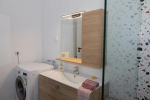 a bathroom with a sink and a washing machine at Alexas country house in Kamena Vourla