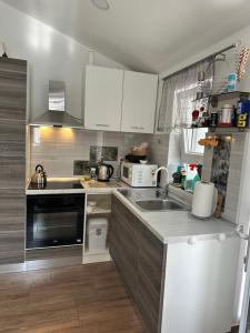 a kitchen with white cabinets and a sink at Lora in Skradin
