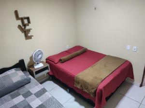a small bedroom with a bed and a fan at Chalé aconchego do Áureo 2 in Pacoti