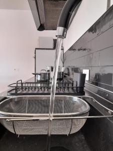 una cucina con un flusso d'acqua che esce da un lavandino di Le Dimore del Sole int 8 a Olbia Altre 30 foto