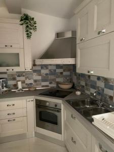 a kitchen with a sink and a stove at Il Pizzuto - Appartamento da Nonna Anna in Bernalda +5 photos