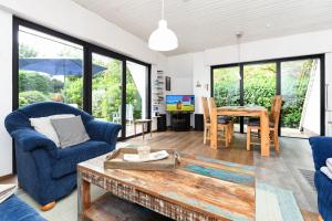 a living room with blue chairs and a table at Ferienhaus Leevje in Neuharlingersiel