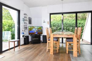 a dining room with a table and chairs and a television at Ferienhaus Leevje in Neuharlingersiel +26 photos