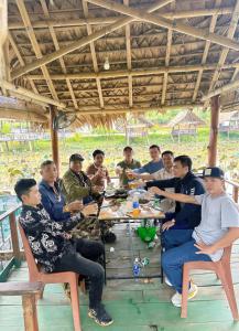 a group of people sitting around a table at Đồi Dẻ Eco HomeStay in Bố Trạch